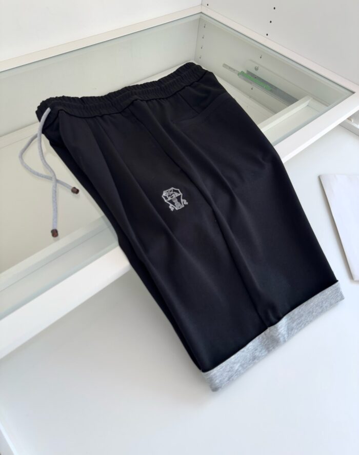 Pantaloni jogger neri con dettaglio grigio alle caviglie e logo minimalista sul fianco.
