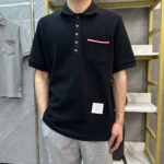 Maglietta polo nera con tasca a righe, stile casual e moderno, ideale per ogni outfit.