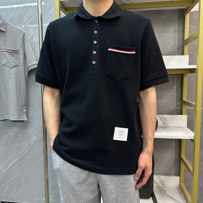 Maglietta polo nera con tasca a righe, stile casual e moderno, ideale per ogni outfit.