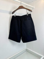 Pantaloncini neri casual su appendiabiti, tessuto morbido e design semplice ed elegante.