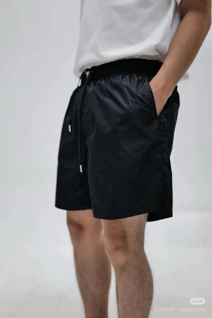 Look estivo casual con shorts neri, T-shirt bianca e stile rilassato.