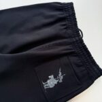 Pantaloncini neri casual con tasca laterale e dettagli ricamati artistici sul retro.