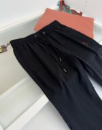 Pantaloni felpati neri casual con tote bag corallo, perfetti per relax e attività quotidiane.