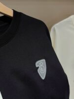 Felpa nera con logo ricamato, stile casual e confortevole, abbinata a capo chiaro in esposizione.