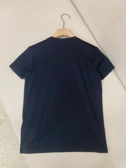 Maglietta nera casual con collo rotondo su gancio di legno, stile semplice e versatile.