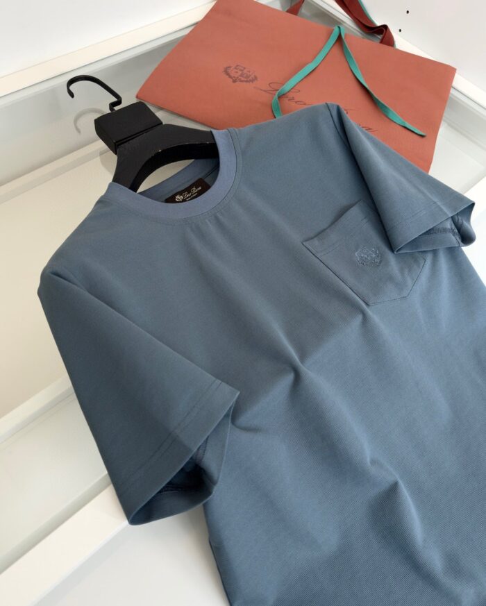 Maglietta blu casual con tasca, borsa beige e dettagli moderni per uno stile quotidiano.