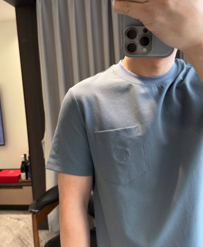 Selfie in casa con maglietta blu chiara, stile casual e ambiente luminoso e accogliente.