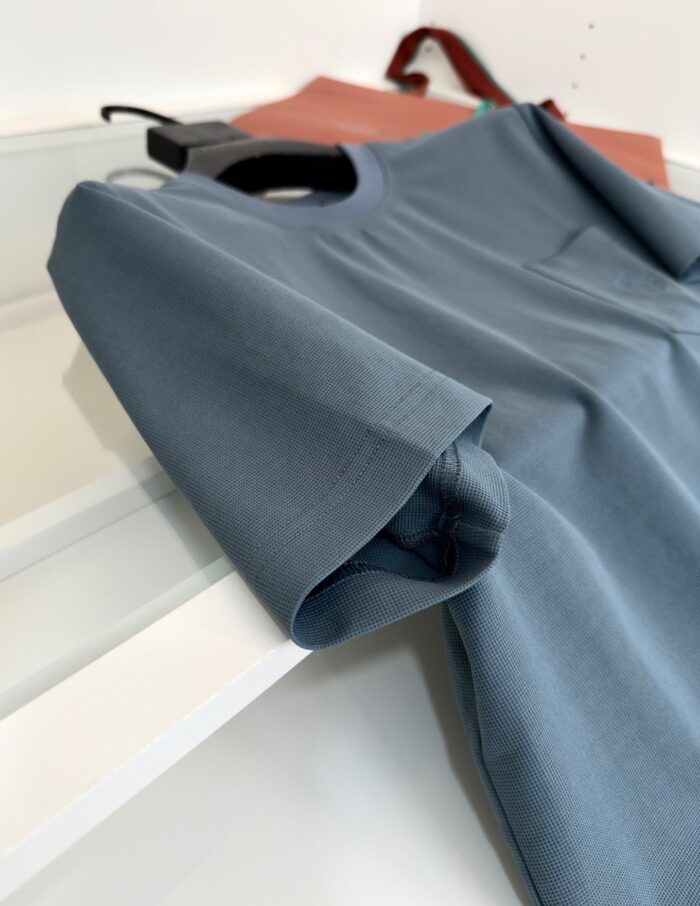 T-shirt blu chiaro casuale con taschino, accompagnata da borsa marrone, stile semplice e alla moda.