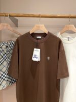 Look casual: maglietta marrone, shorts a quadri e t-shirt bianca su esposizione elegante.