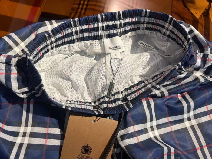 Pantaloncini a quadri navy, rosso e bianco con elastico regolabile e stile classico.