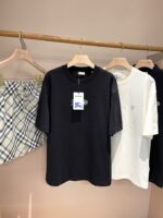 Esposizione di abbigliamento casual: t-shirt nera, bianca oversize e gonna a quadri colorati.