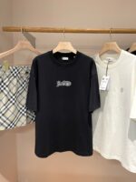 Display di abbigliamento casual con T-shirt nere, bianche e shorts checkered estivi.
