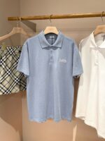 Abbigliamento uomo estivo: polo azzurra, camicia bianca e pantaloncini scozzesi.