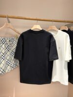 Display casual con magliette nere e bianche e gonna a quadri in negozio minimalista.