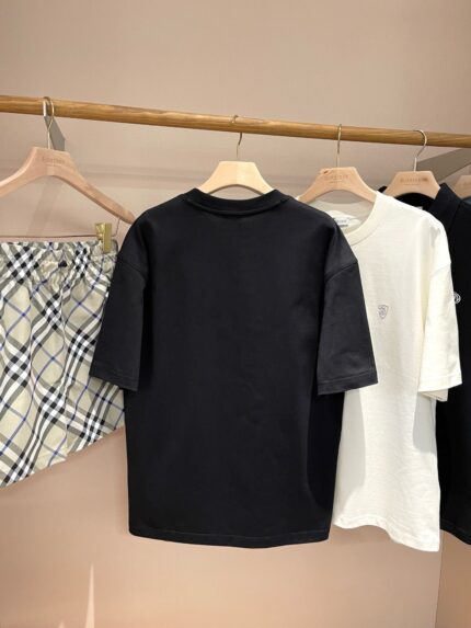 Display casual con magliette nere e bianche e gonna a quadri in negozio minimalista.
