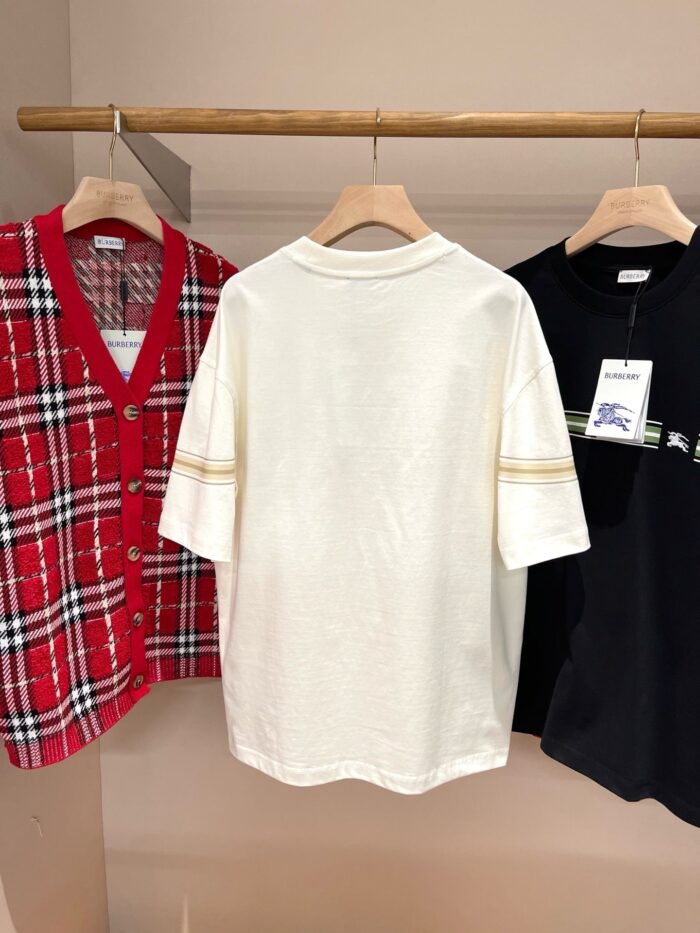 Esposizione di cardigan a quadri, T-shirt bianco e camicia nera in negozio di moda casual.