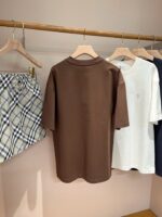 Esposizione di abbigliamento casual moderno con t-shirt, shorts a quadri e stile minimalista.