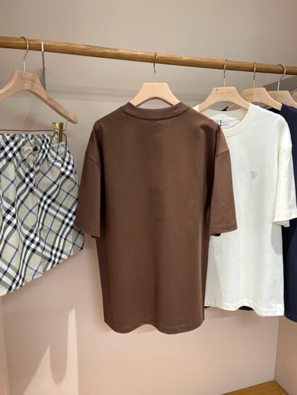 Esposizione di abbigliamento casual moderno con t-shirt, shorts a quadri e stile minimalista.