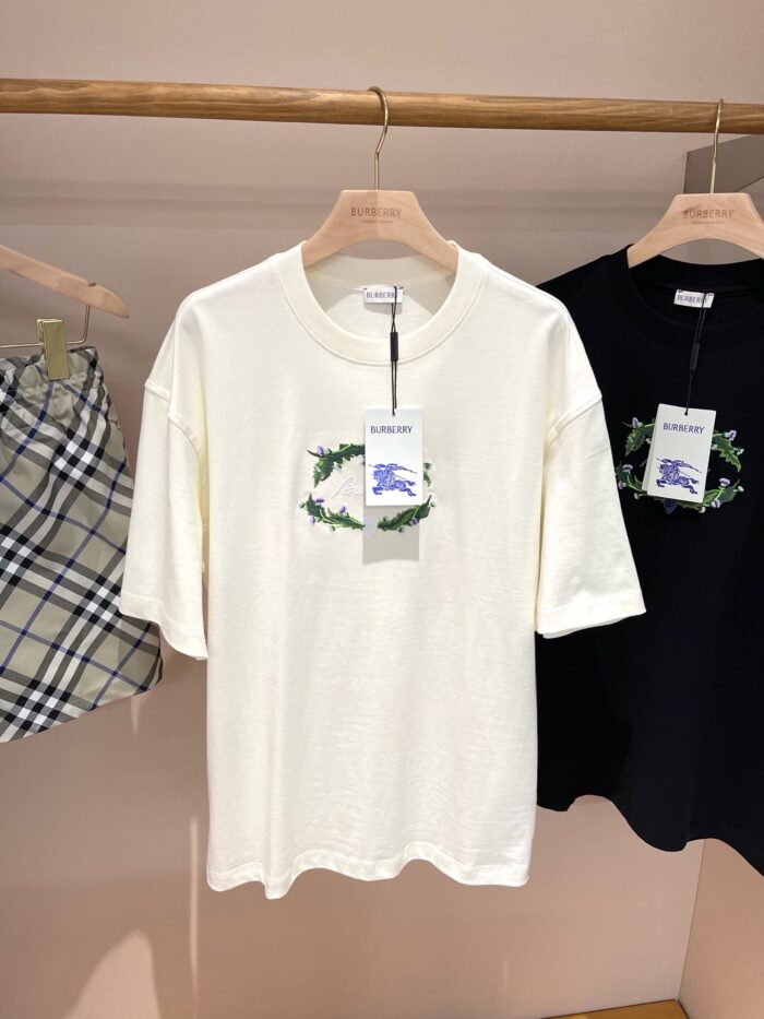 Maglietta crema con ricamo verde, stile casual, abbigliamento moderno e accessori in vetrina.