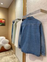Esposizione di giacche in denim e camicie pastello in un negozio moderno e elegante.