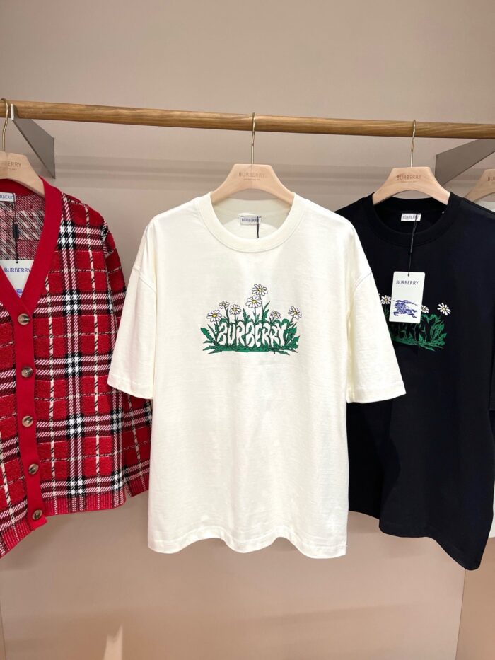 Esposizione di abbigliamento moderno: t-shirt grafica, cardigan a scacchi e top nero elegante.