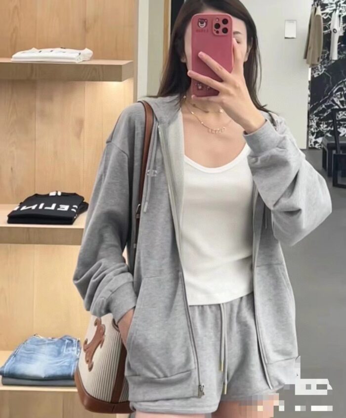 Donna con outfit casual in negozio, scatta selfie davanti allo specchio, stile comodo e alla moda.