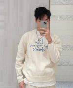 Selfie in stile moderno con maglione Dior, atmosfera luminosa e look giovane e casual.