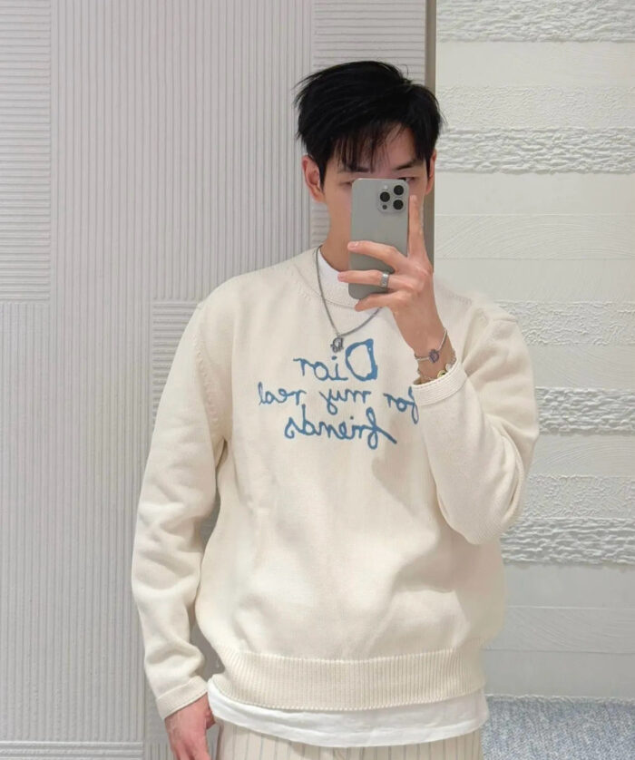 Selfie in stile moderno con maglione Dior, atmosfera luminosa e look giovane e casual.