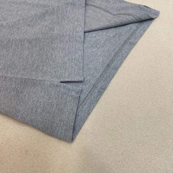 Camicetta grigia in cotone morbido con bordo cucito, stile casual elegante, ideale per ogni stagione.