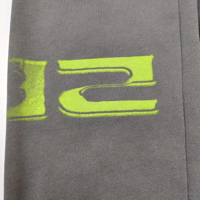 Maglietta grigia con grafica neon verde moderna, stile sportivo e casual, per look giovane e trendy.
