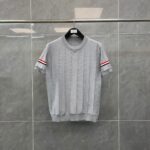 Maglietta casual grigia con dettagli a strisce rosse e dritte alle maniche.