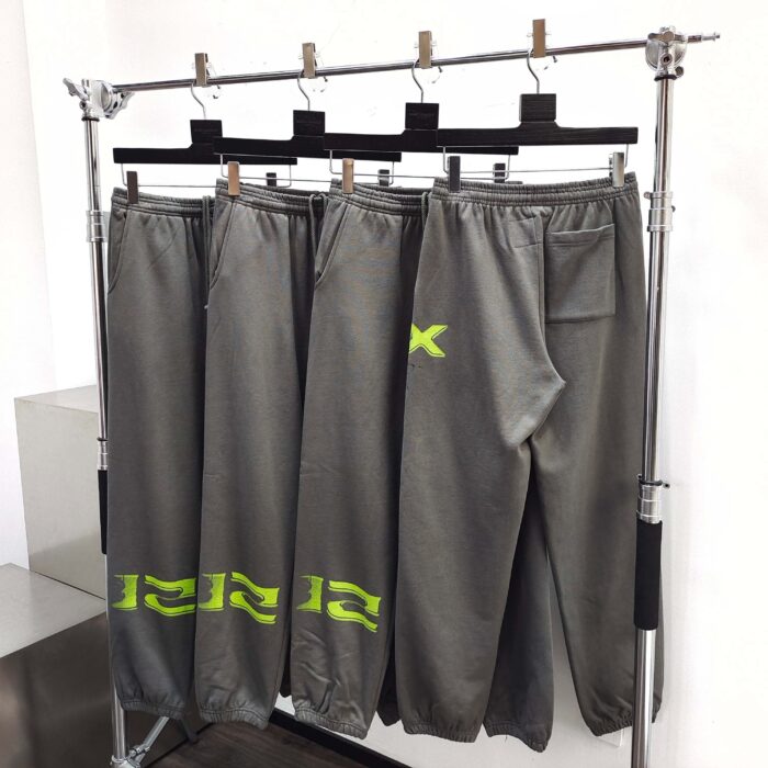 Pantaloni sportivi grigi con dettagli fluo, stile moderno e pratico per attività casual e fitness.