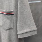 Camicia casual grigia con tasca a strisce colorate, stile rilassato e dettagli eleganti.