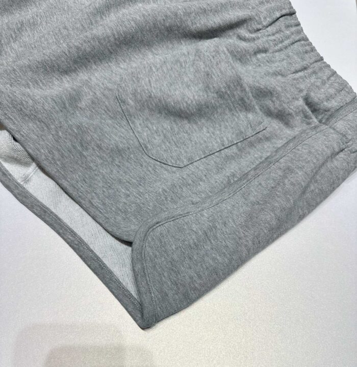 Pantaloncini grigi casual con elastico, tasca e risvolti, perfetti per relax e movimento.
