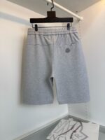 Pantaloncini grigi casual da uomo con vita elastica, esposti su appendiabiti nero in negozio.