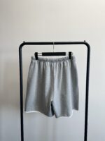 Pantaloncini sportivi grigi eleganti su esposizione minimalista, ideali per casual e allenamento.