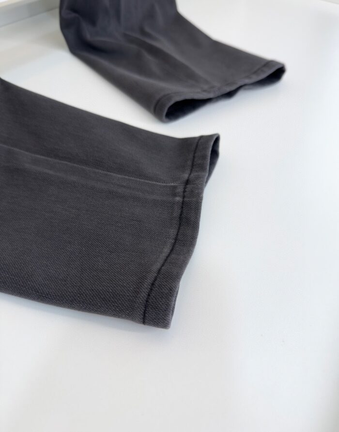 Maniche grigie casual con polsini arrotolati, tessuto morbido e stile minimalista.