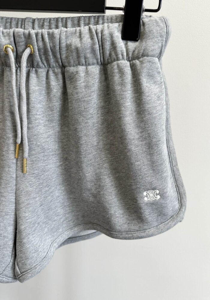 Pantaloncini sportivi grigi con cintura elastica, logo minimal, ideali per fitness e casual.