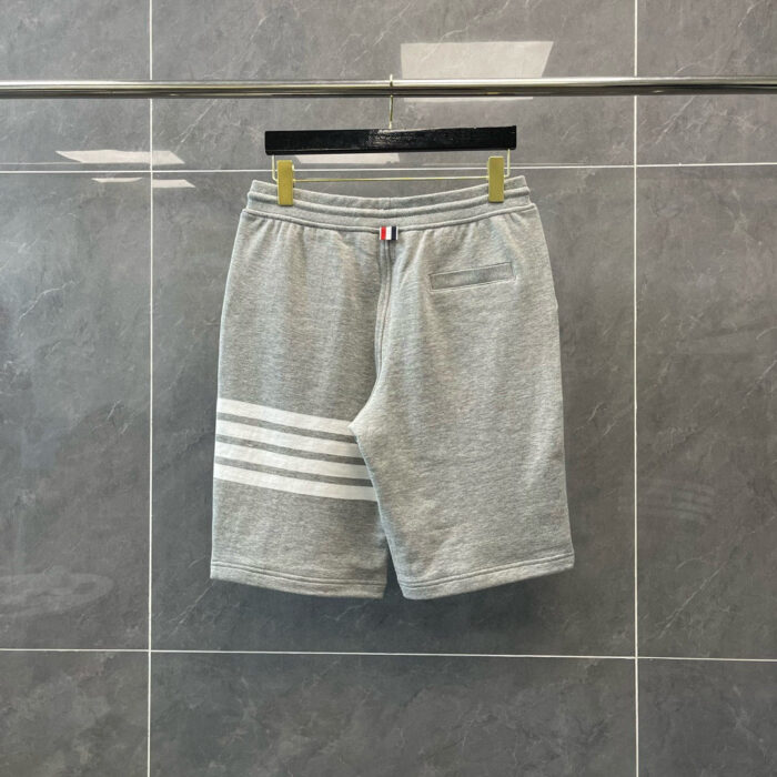 Pantaloncini sportivi grigi con strisce, comodi e stile casual, ideali per attività sportive e relax.