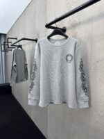Felpa grigia casual con ricami floreali e logo frontale, stile moderno e versatile.