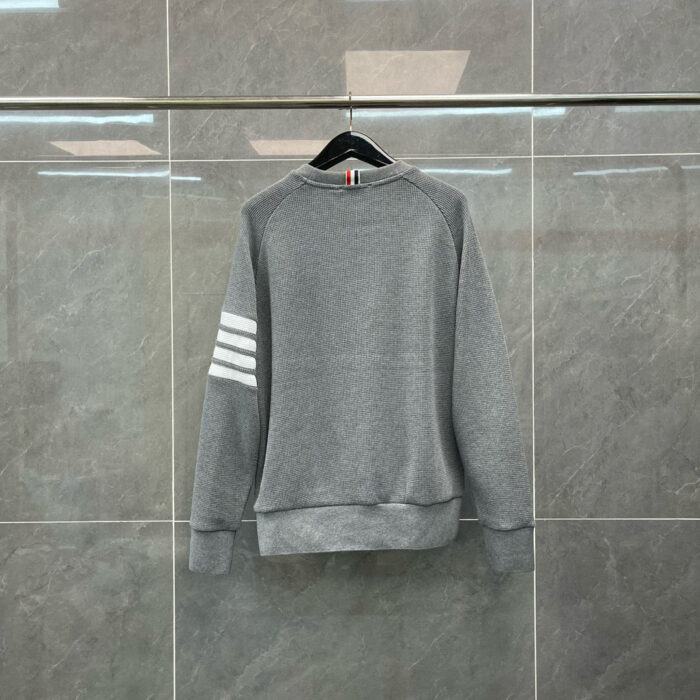 Felpa grigia con dettagli sportivi e design versatile, ideale per look casual e attività sportive.