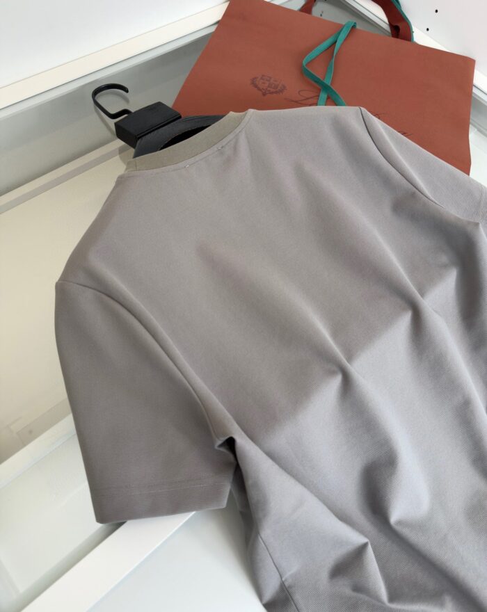 Maglietta grigia casual con borsa tote in pelle marrone, stile semplice ed elegante.