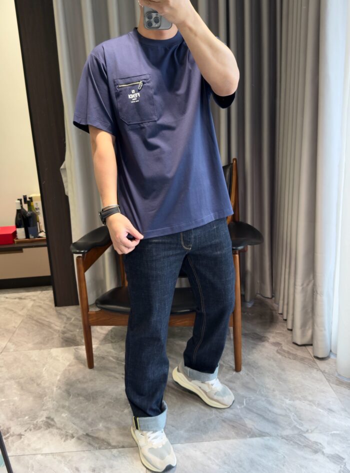 Abbigliamento casual con t-shirt navy, jeans dark e sneakers bianchi alla moda.