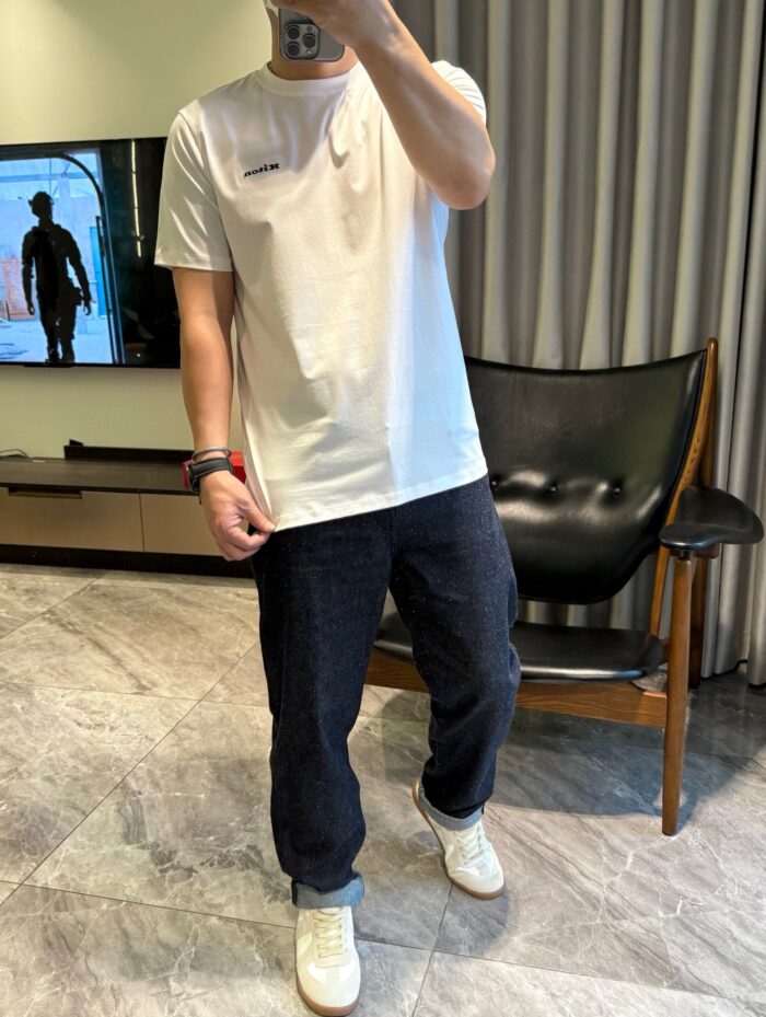 Look casual e elegante in salotto con t-shirt bianca, joggers blu e sneakers bianchi.