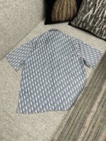 Camicia azzurro con motivo geometrico, stile casual, su divano accogliente con cuscini.