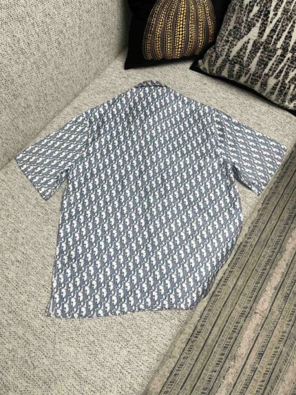 Camicia azzurro con motivo geometrico, stile casual, su divano accogliente con cuscini.