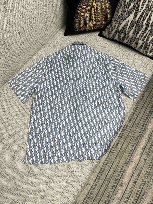 Camicia azzurro con motivo geometrico, stile casual, su divano accogliente con cuscini.
