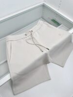 Pantaloncini casual chiari con nastro regolabile e tasche, stile minimalista e comfort quotidiano.