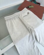 Pantaloni casual chiari con elastico e borsa tote moderna, stile rilassato e raffinato.