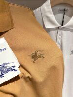 Polo di lusso bianca e marrone, eleganti, con dettagli ricamati e stile casual chic.
